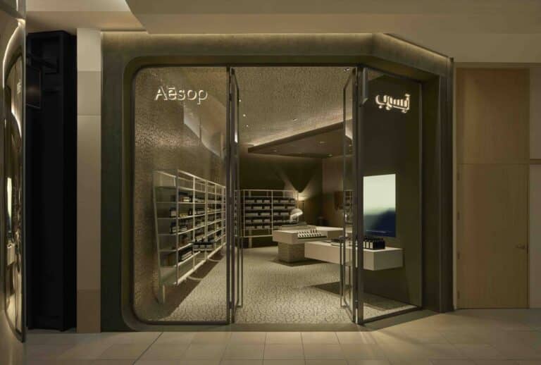 inside Aesop Red Sea Mall, the same tension of forms plays out as two volumes—one linear, one fluid—spill into each other